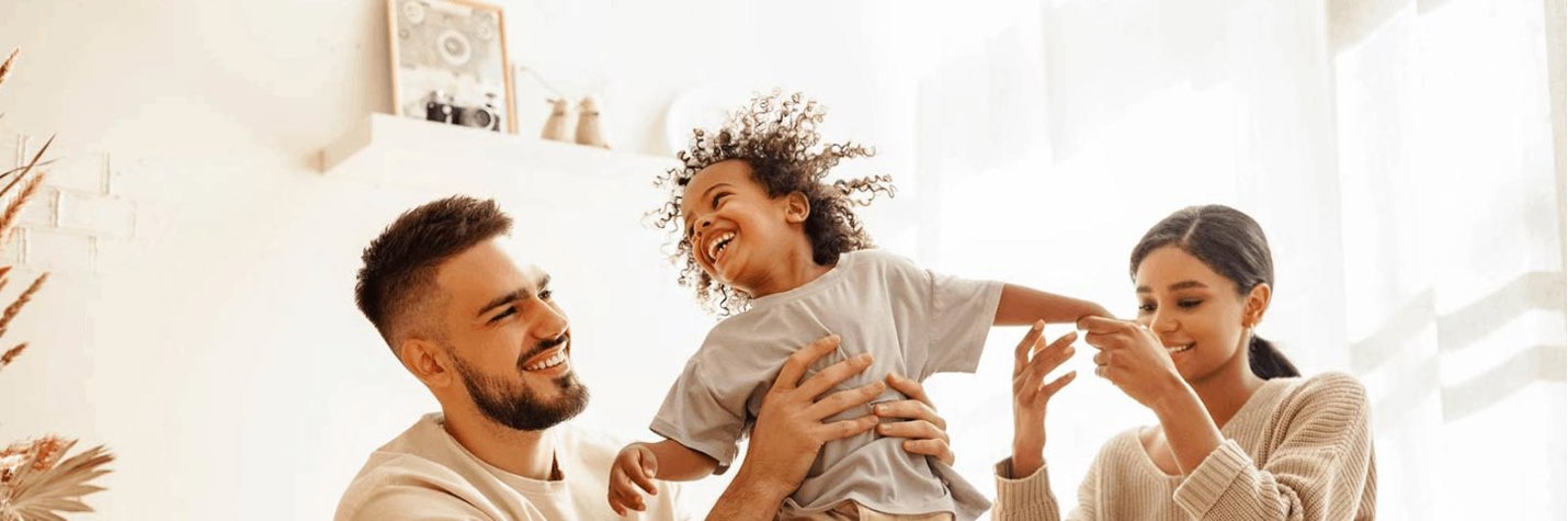 Young family playing helicopter with their son