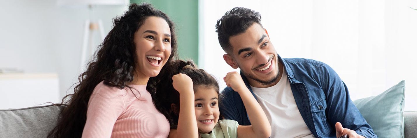 Young family sitting on the couch watching a movie