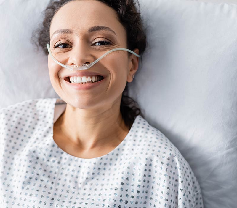 Woman lying in bed doing oxygen therapy